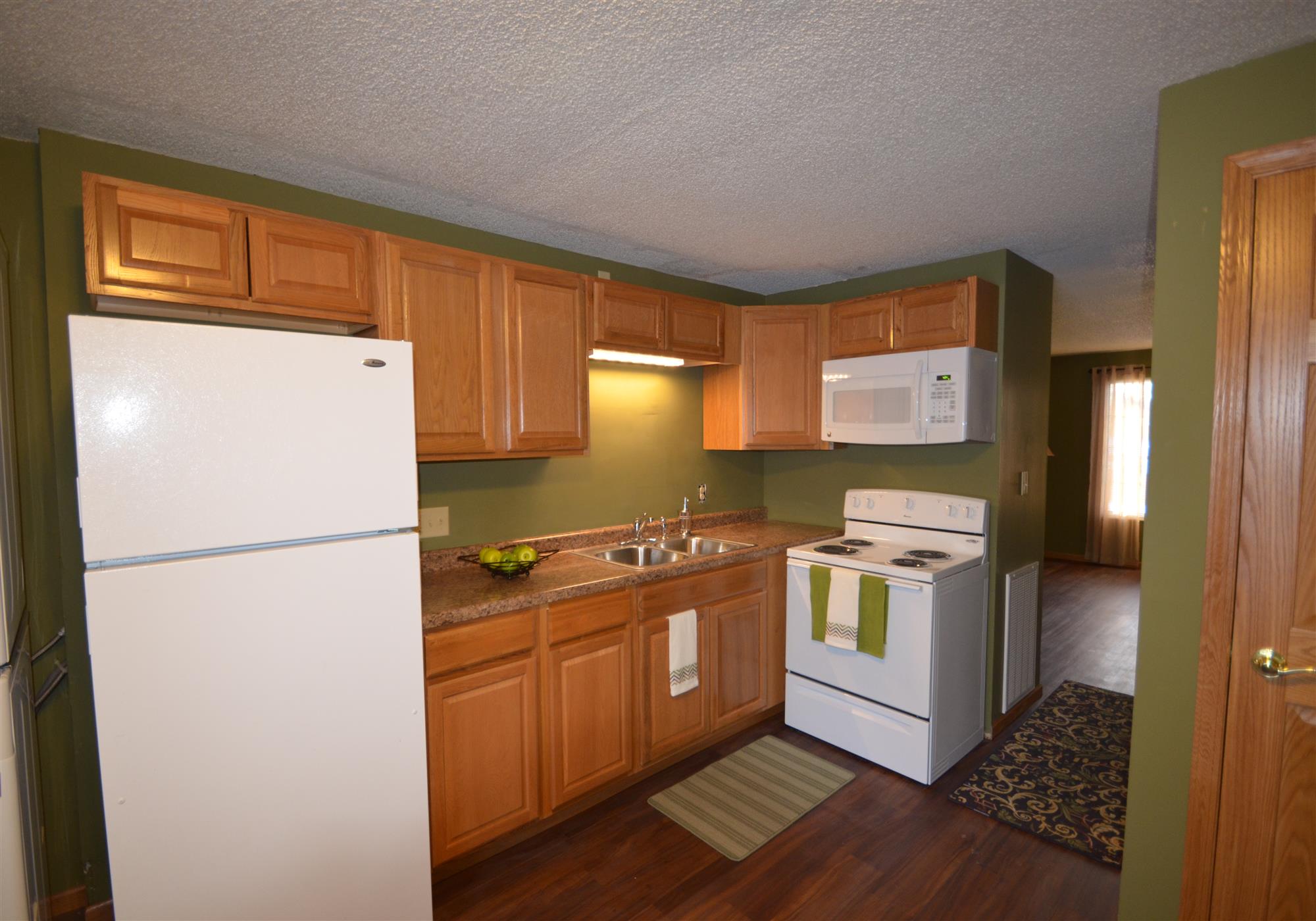 a kitchen with white appliances and wooden cabinets