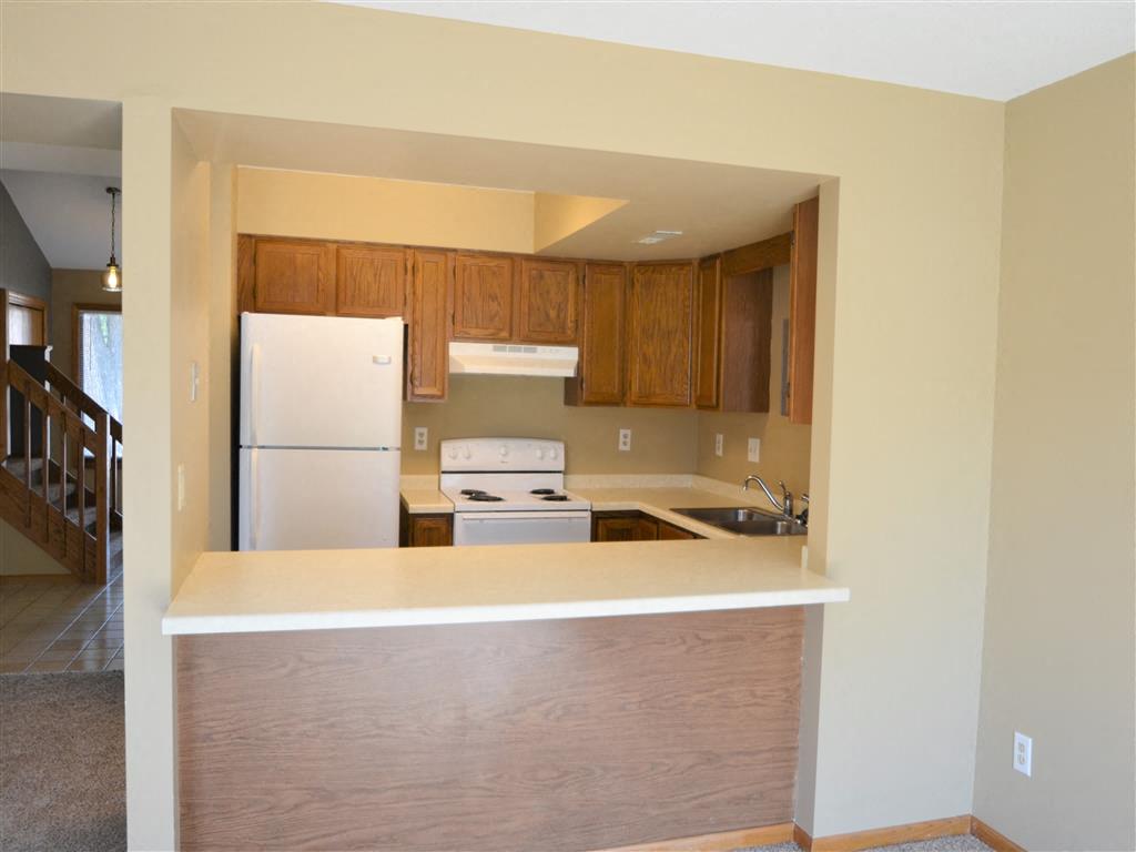 a kitchen with white appliances and wooden cabinets