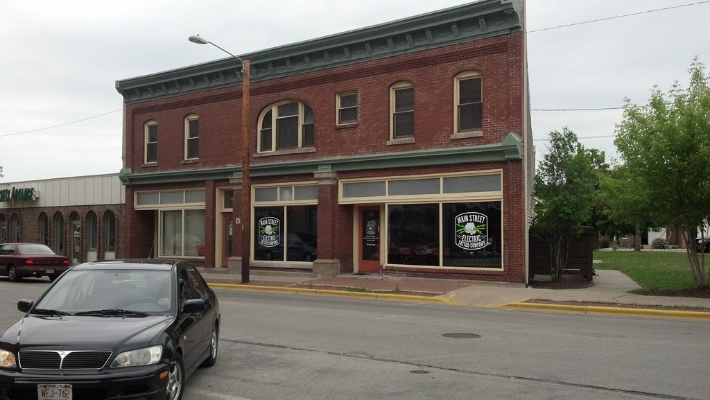 an old brick building with a car parked on the street