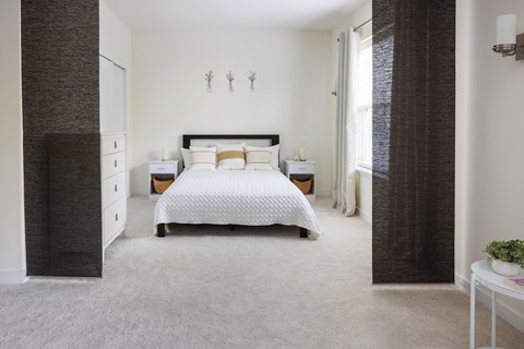 A bedroom with a large bed and a dresser.