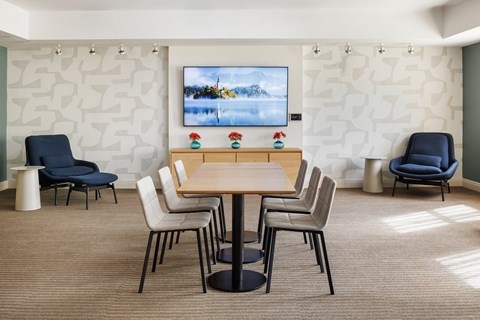 A conference room with a large screen and chairs.