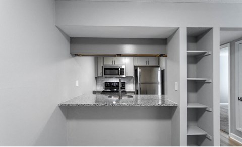 a kitchen with a granite counter top and a refrigerator
