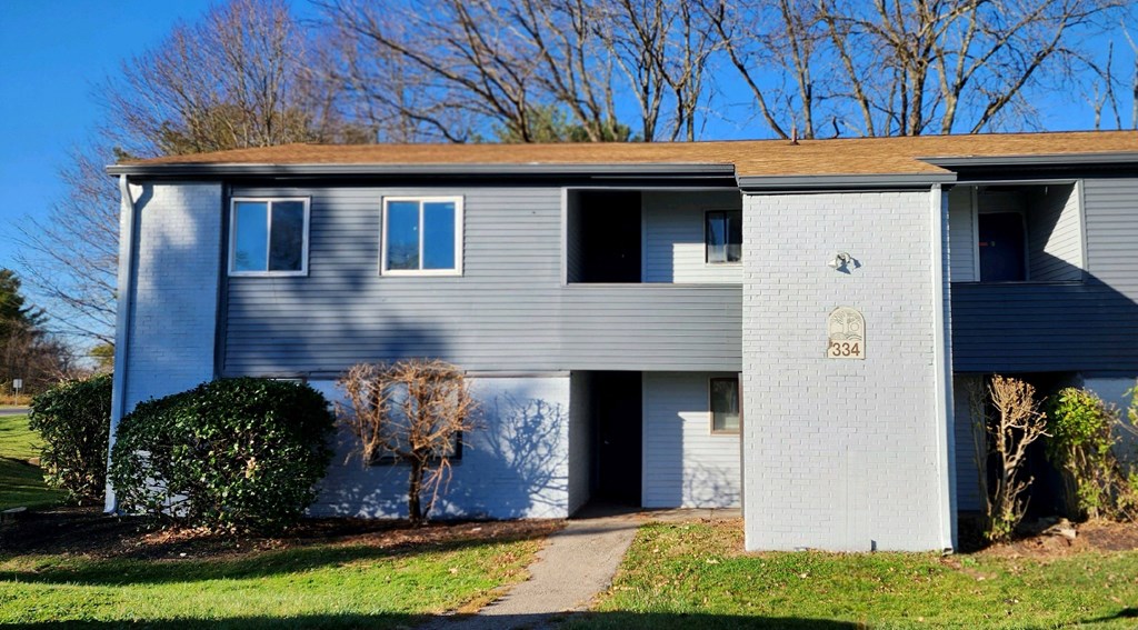a blue and white house with a sidewalk in front of it