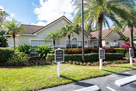 a house with palm trees and signs in front of it