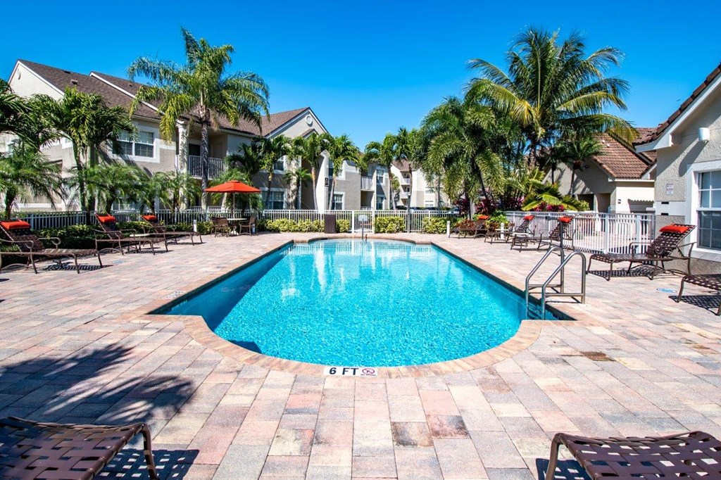 a swimming pool with palm trees in front of a house