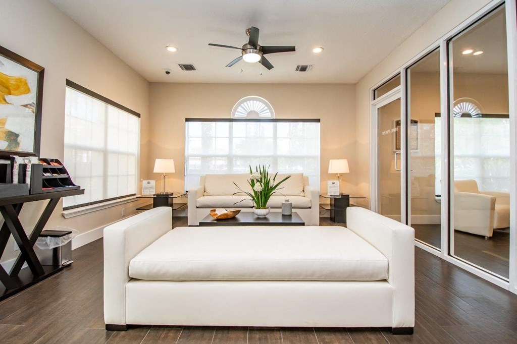a living room with a white couch and a ceiling fan