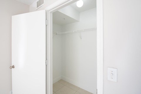 an empty room with a white wall and a door to a closet