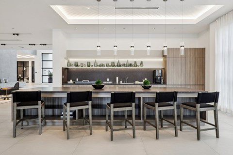 A modern kitchen with a long table and chairs.