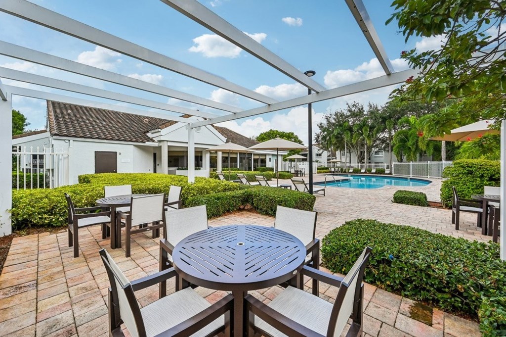 A patio with a table and chairs is covered by a white awning.