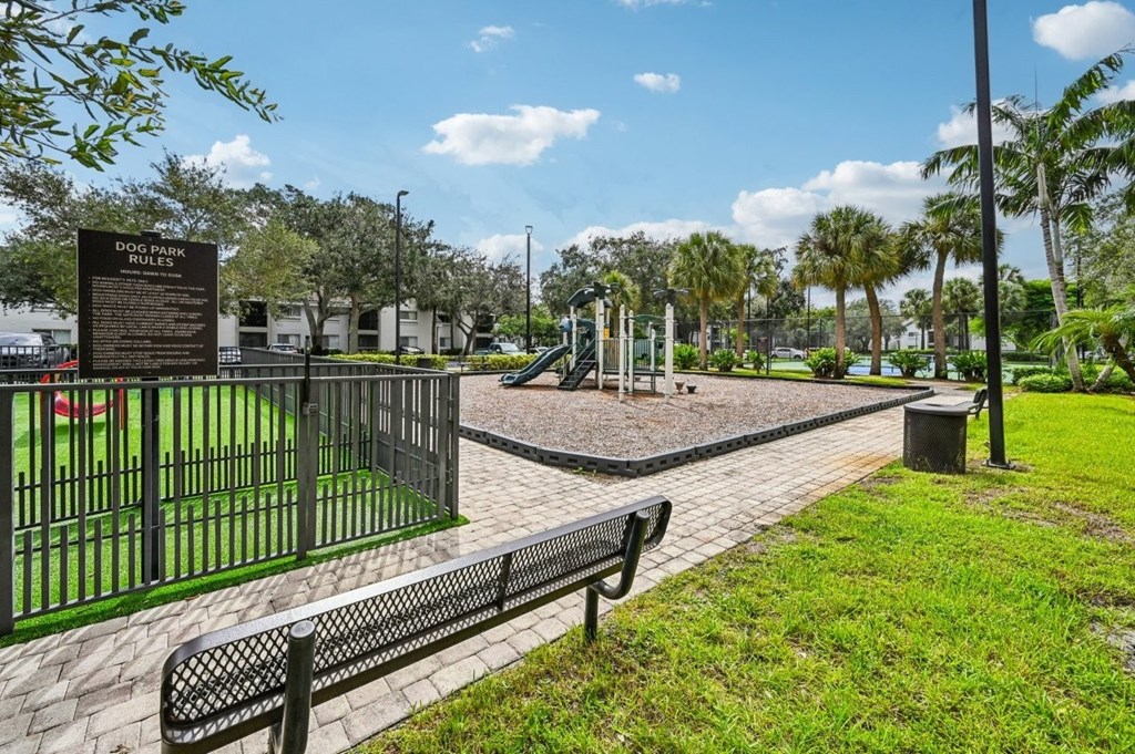 A sign in a park reads "DOG PARK".