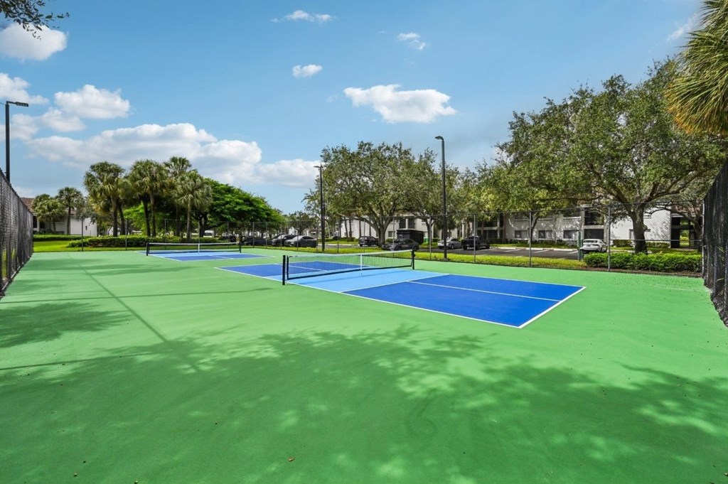 A tennis court with blue and green surface and white lines.