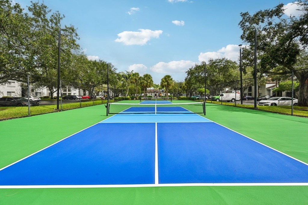 A blue and green tennis court with a white line down the middle.
