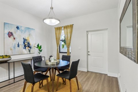 A dining room with a table set for four.