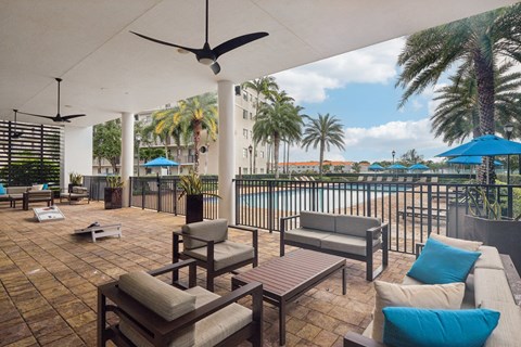 A patio with a table and chairs overlooking a pool.