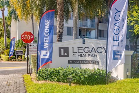 a sign for legacy apartments in front of a building