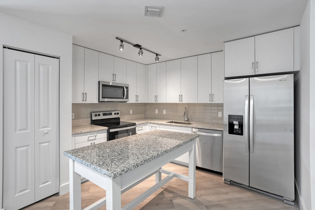 a kitchen with white cabinets and a granite counter top