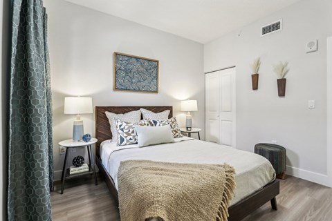 A bedroom with a large bed and a painting on the wall.