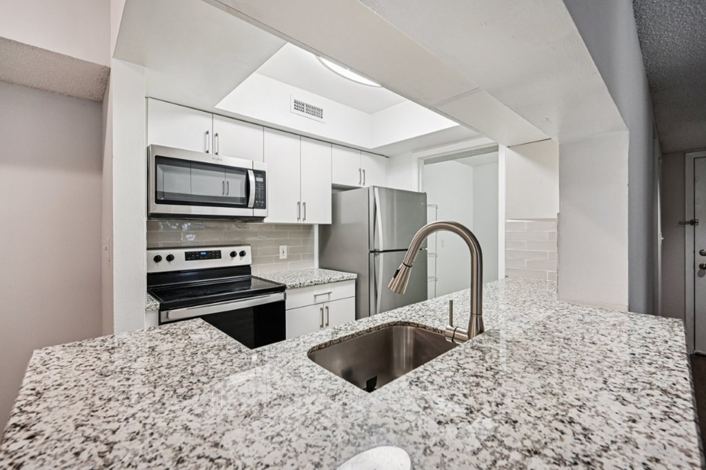 A kitchen with granite countertops and stainless steel appliances.