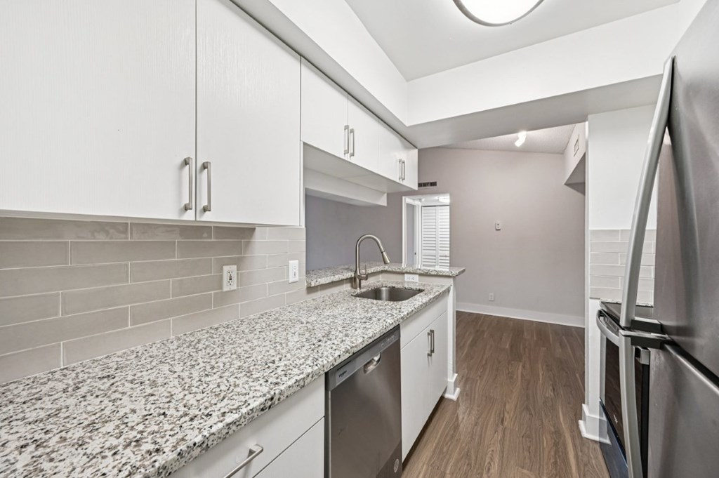 A kitchen with a granite countertop and stainless steel appliances.