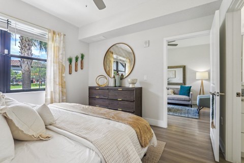 A bedroom with a large bed and a mirror above it.