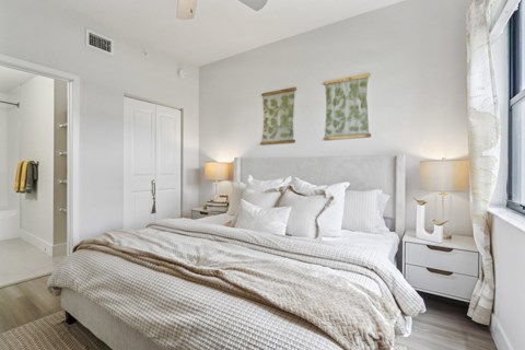 A bedroom with a large bed and two nightstands.