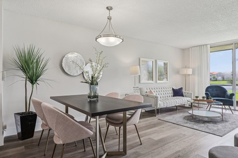 A modern dining room with a black table and chairs.