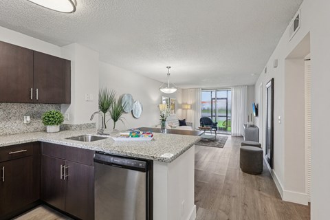 A kitchen with dark wood cabinets and a granite countertop.
