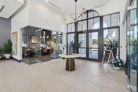 A modern interior space with a glass wall and a table with a plant on it.
