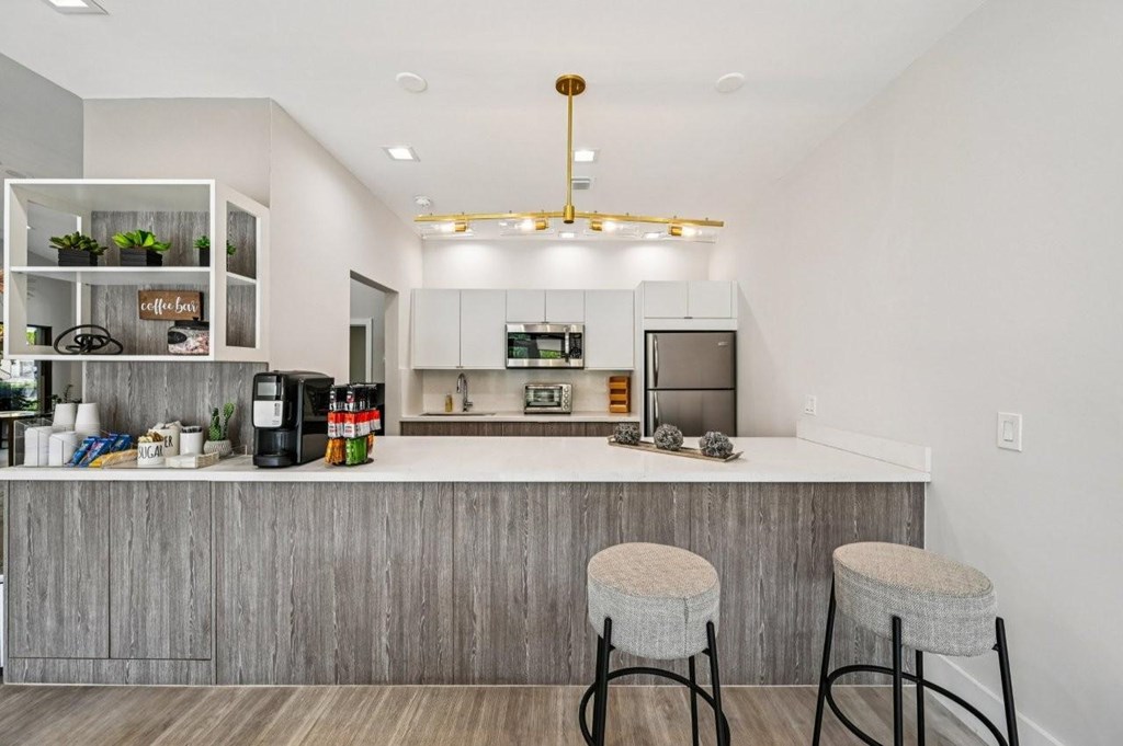 A modern kitchen with a bar stool in front of it.