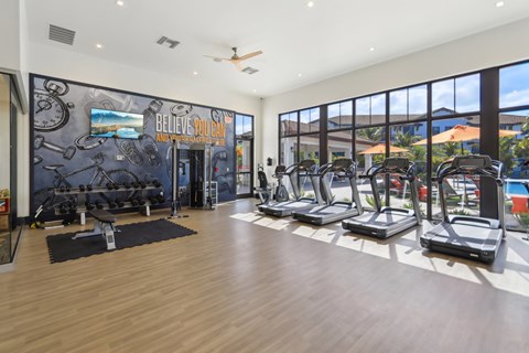 A gym with treadmills and a motivational wall.
