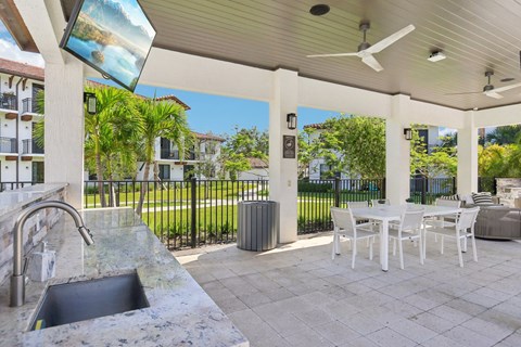A patio with a table and chairs and a fan.
