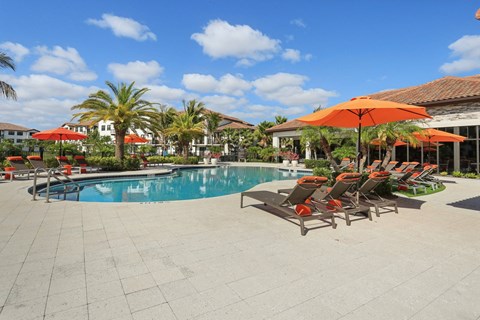 A pool area with chairs and umbrellas.