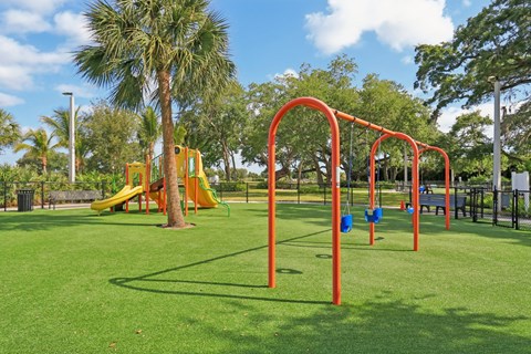 A playground with a yellow slide and red monkey bars.
