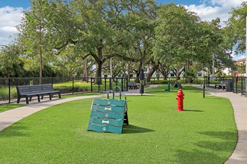 A park with a red fire hydrant and a green slide.