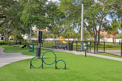 A park with a green grass area and a playground.
