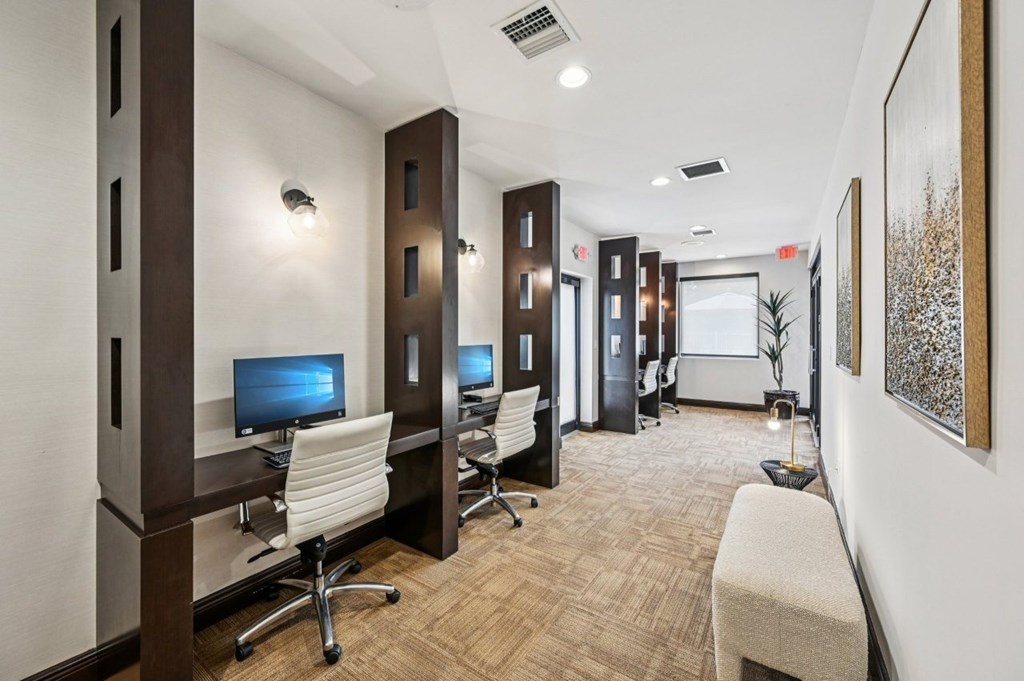 A room with brown carpet and brown walls has a computer on a desk.