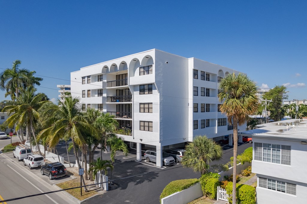 a large white building with palm trees in front of it