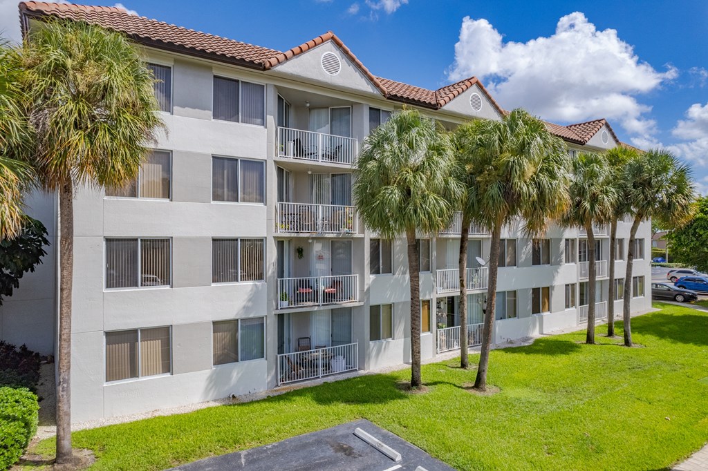 an apartment building with palm trees in front of it