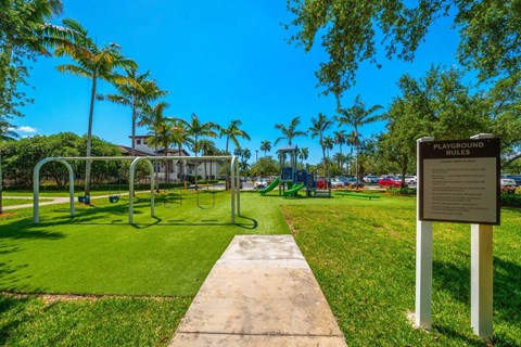 A sign in a park outlines the playground rules.