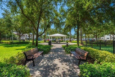 A park with benches and trees.