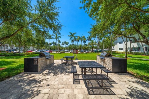 A park with a picnic table surrounded by trees.