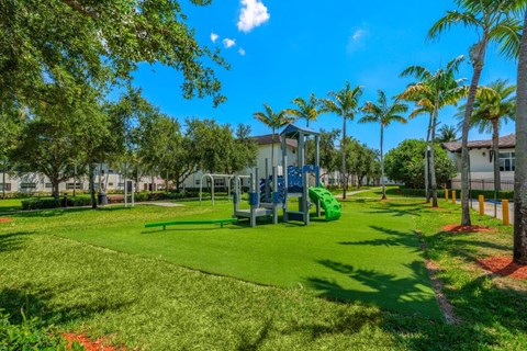 A playground with a green slide and a blue swing set.