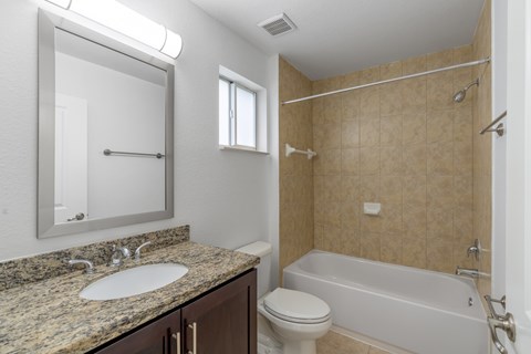 A bathroom with a sink, toilet, and bathtub.