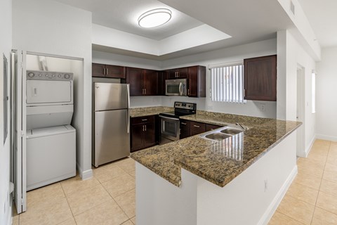 A kitchen with granite countertops and stainless steel appliances.