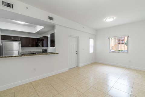 A spacious room with a kitchen area and a window.