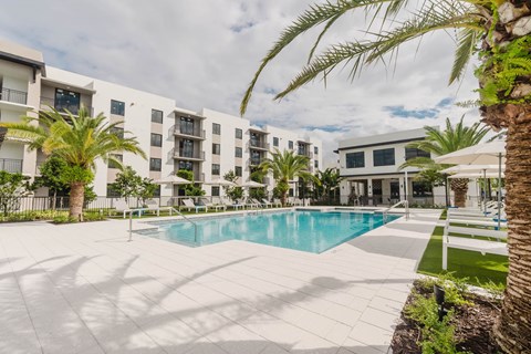A large white building with a pool in front.