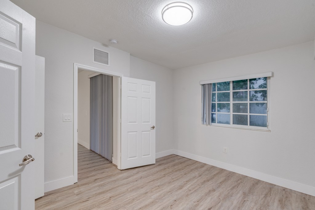 an empty living room with white walls and wood flooring