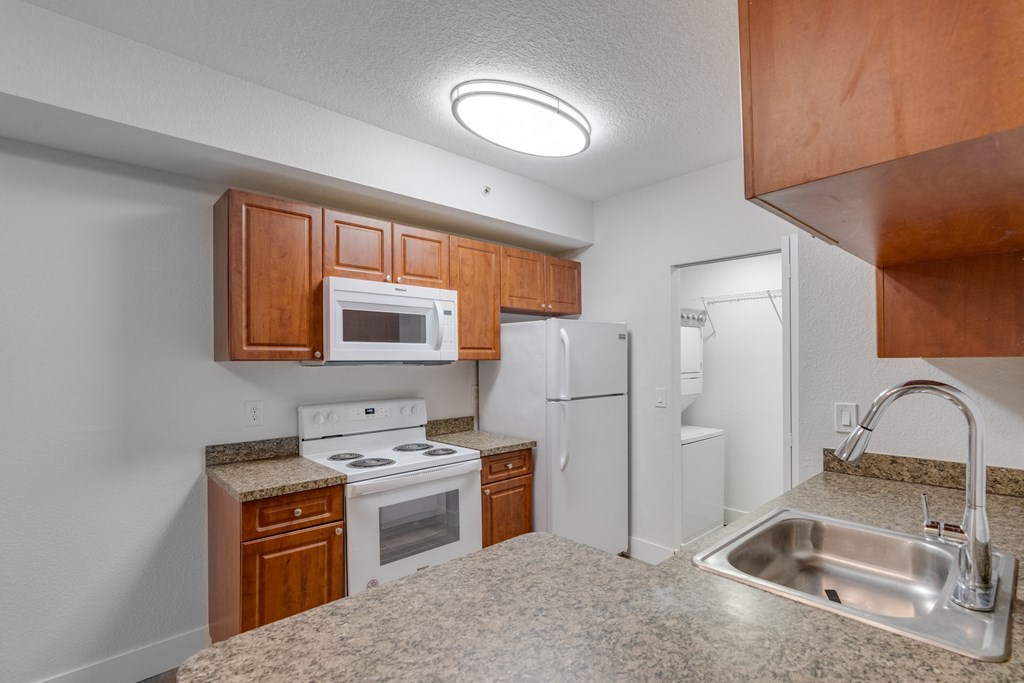 a kitchen with white appliances and granite counter tops