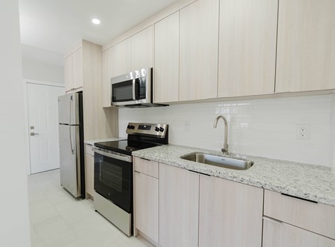 A kitchen with white cabinets and appliances.