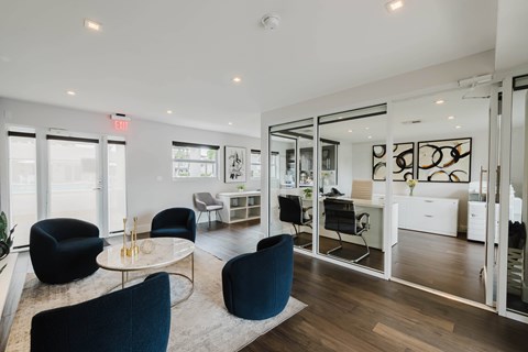 A modern office space with black chairs and a glass wall.